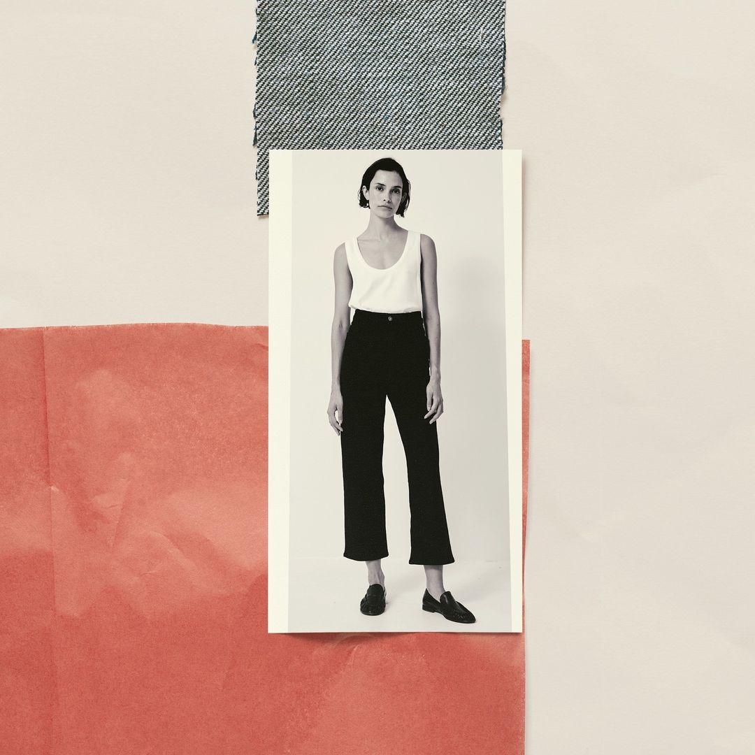 Black and white fashion portrait of a woman wearing a white tank top and black slacks with denim and coral fabric swatches.
