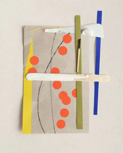 Abstract art collage featuring paper scraps, matchstick, popsicle stick, and orange dots, set against a neutral background.