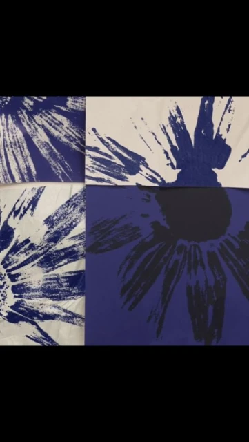 Abstract artwork features a grid of four squares, each displaying a flower design in shades of blue and white, creating a visually striking pattern.