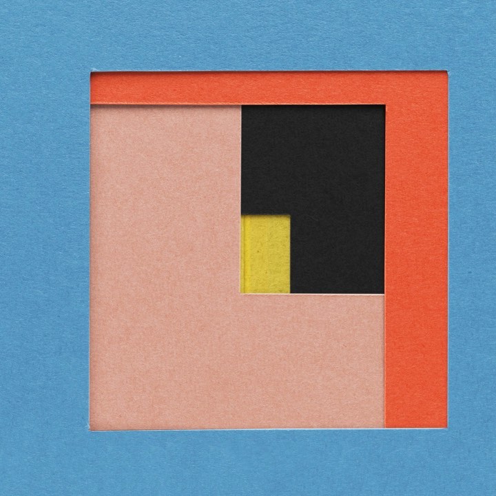 Abstract layered paper art featuring squares and rectangles in blue, coral, yellow, and black, presented as a framed composition.