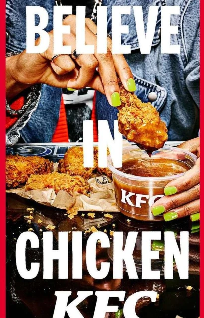 Close-up of a person holding a KFC fried chicken drumstick over a container of dipping sauce, with more chicken pieces on a plate.