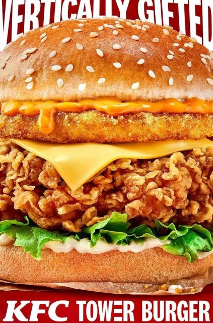 Towering KFC burger featuring a crispy chicken patty, cheese, lettuce, and special sauce stacked between a seeded bun, food photography.