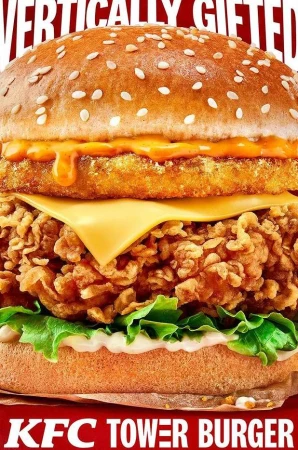 Towering KFC burger featuring a crispy chicken patty, cheese, lettuce, and special sauce stacked between a seeded bun, food photography.