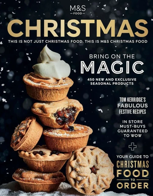 Christmas magazine cover featuring a stacked tower of mince pies with cream against a dark background with snowfall effect.