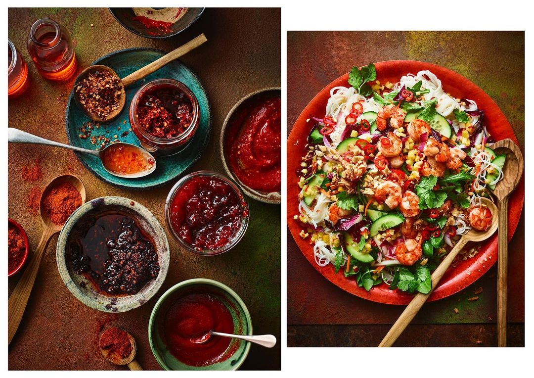Overhead food photography: Thai shrimp salad with rice noodles, chili garlic sauce, and various vibrant ingredients.