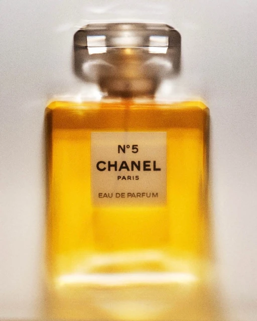 Close-up studio shot of Chanel N°5 Eau de Parfum bottle, showcasing its golden liquid, transparent glass, and minimalist label design.