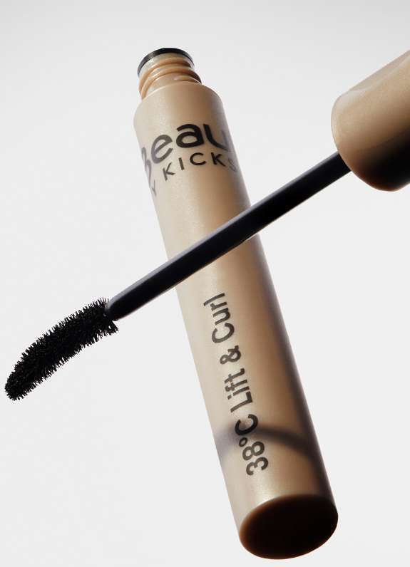 Close-up shot of a tube of Beauty Kicks 38°C Lift & Curl mascara with applicator brush against a white background in a studio.