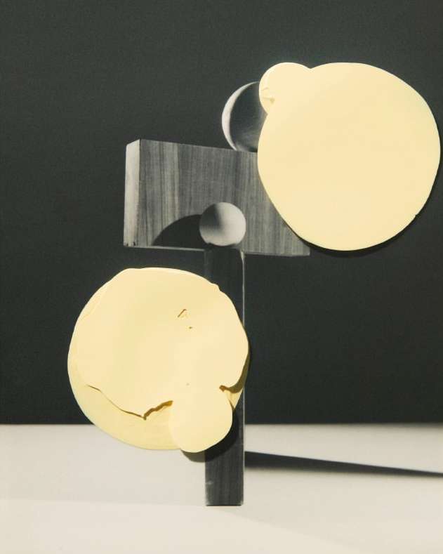 Abstract art featuring geometric shapes in yellow, grey, and black with minimalist composition and balanced visual elements on neutral backdrop.