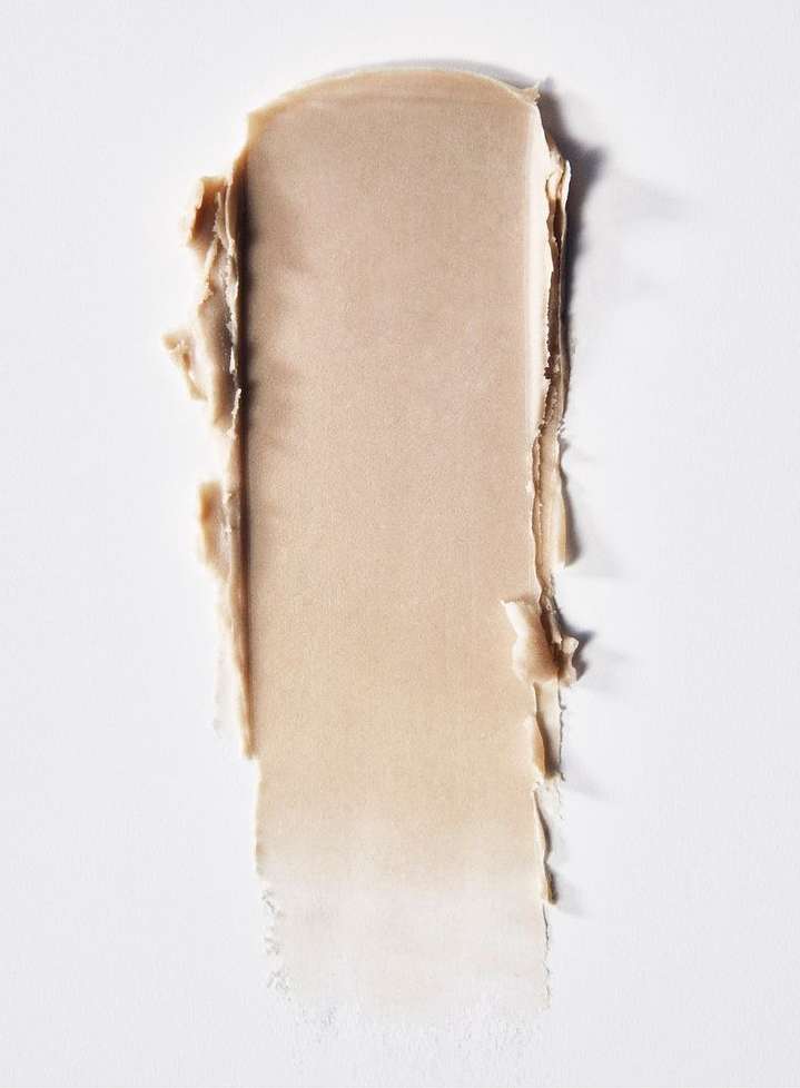 Close-up of a beige-colored cosmetic cream smear on a white surface, showing texture and tone, ideal for beauty or skincare product promotion.