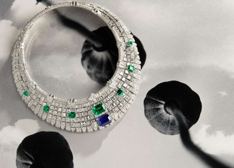 Necklace with green and blue stones on a black and white floral background in a fine art studio shot for a jewelry campaign.
