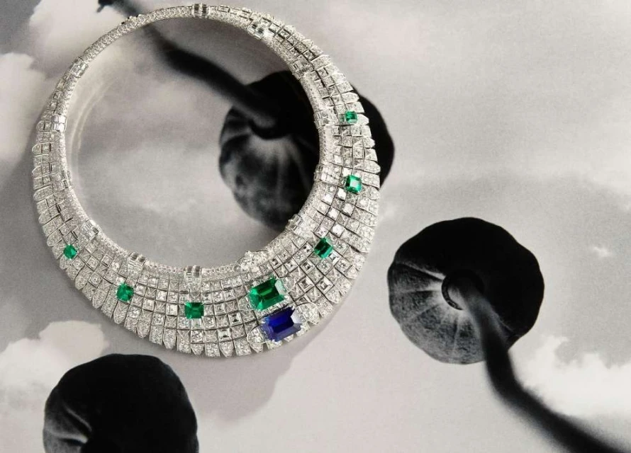 Necklace with green and blue stones on a black and white floral background in a fine art studio shot for a jewelry campaign.