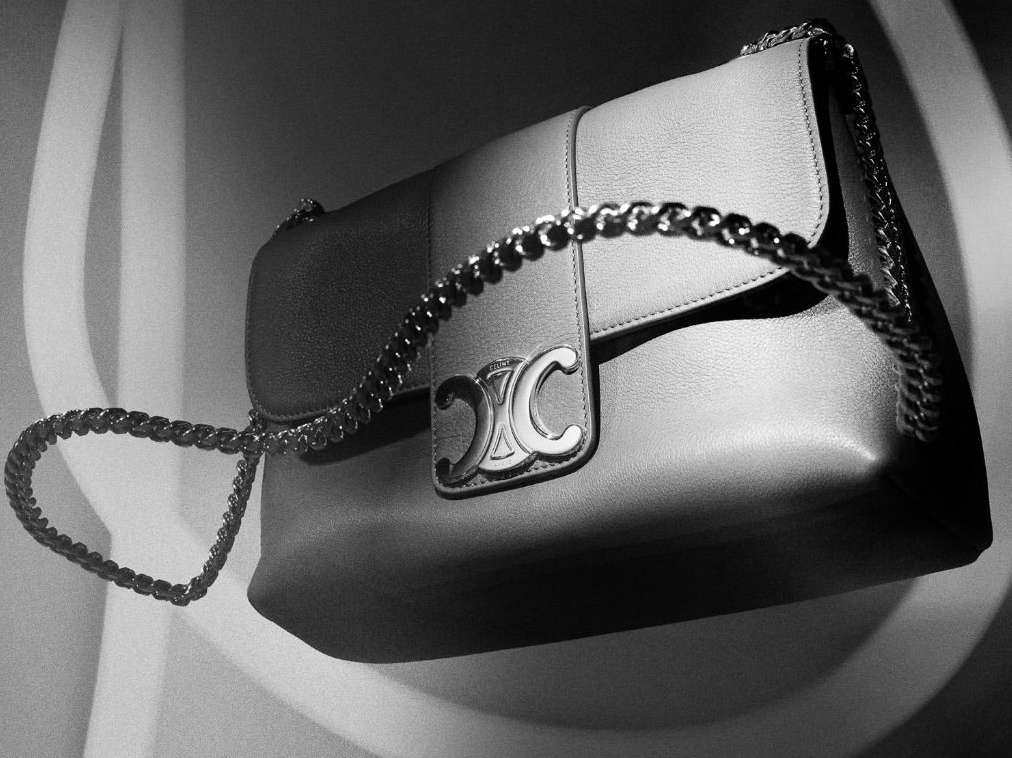 Elegant Celine handbag with a chain strap in a high-contrast black and white studio shot, showcasing luxury fashion accessory and craftsmanship.