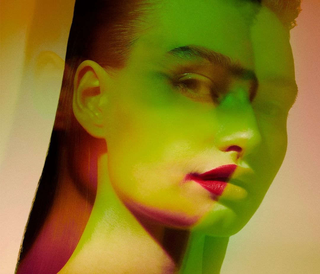 Close-up portrait of a woman's face with red lipstick, and green and yellow color grading for beauty or fashion advertising.
