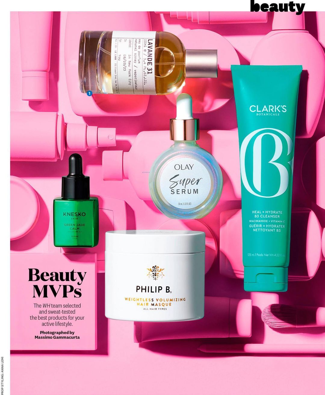 Cosmetic product flat lay on pink backdrop features green serum, face cream, aromatherapy oil, face wash, and editorial beauty text.