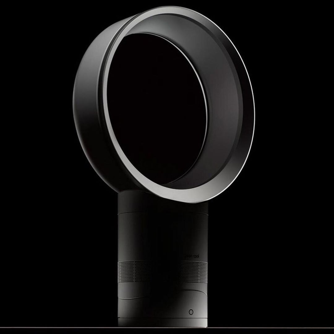 Black and silver bladeless fan isolated on a black background. Modern design for air circulation and cooling in home or office.