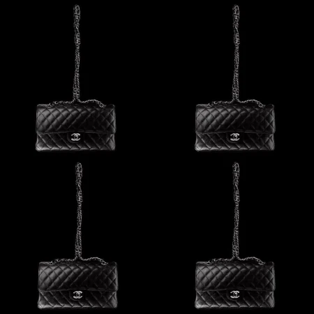 Four black quilted Chanel flap bags with silver chain straps arranged symmetrically against a solid black backdrop.