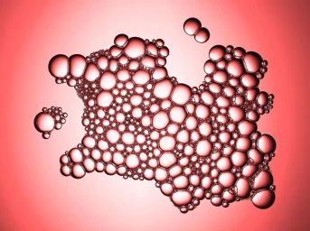 Macro photograph of clustered pink bubbles forming a dense organic shape against a solid pink background.