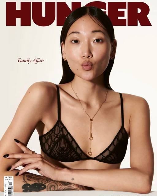 Asian woman poses in a black bra and necklace for a fashion magazine cover. Hunger magazine logo and text 'Family Affair' visible.