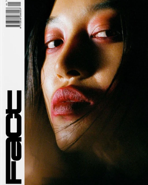 Close-up portrait of a woman with dark hair and red makeup, lips pursed, against a dark background, with 'FACE' text overlay.