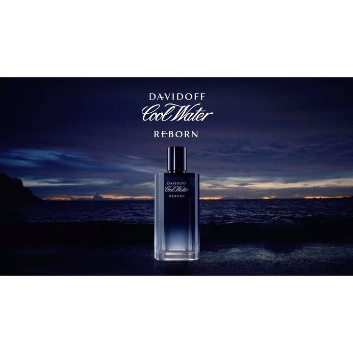 Davidoff Cool Water Reborn fragrance bottle stands in front of a dramatic seascape with dark blue hues, brand logo above.