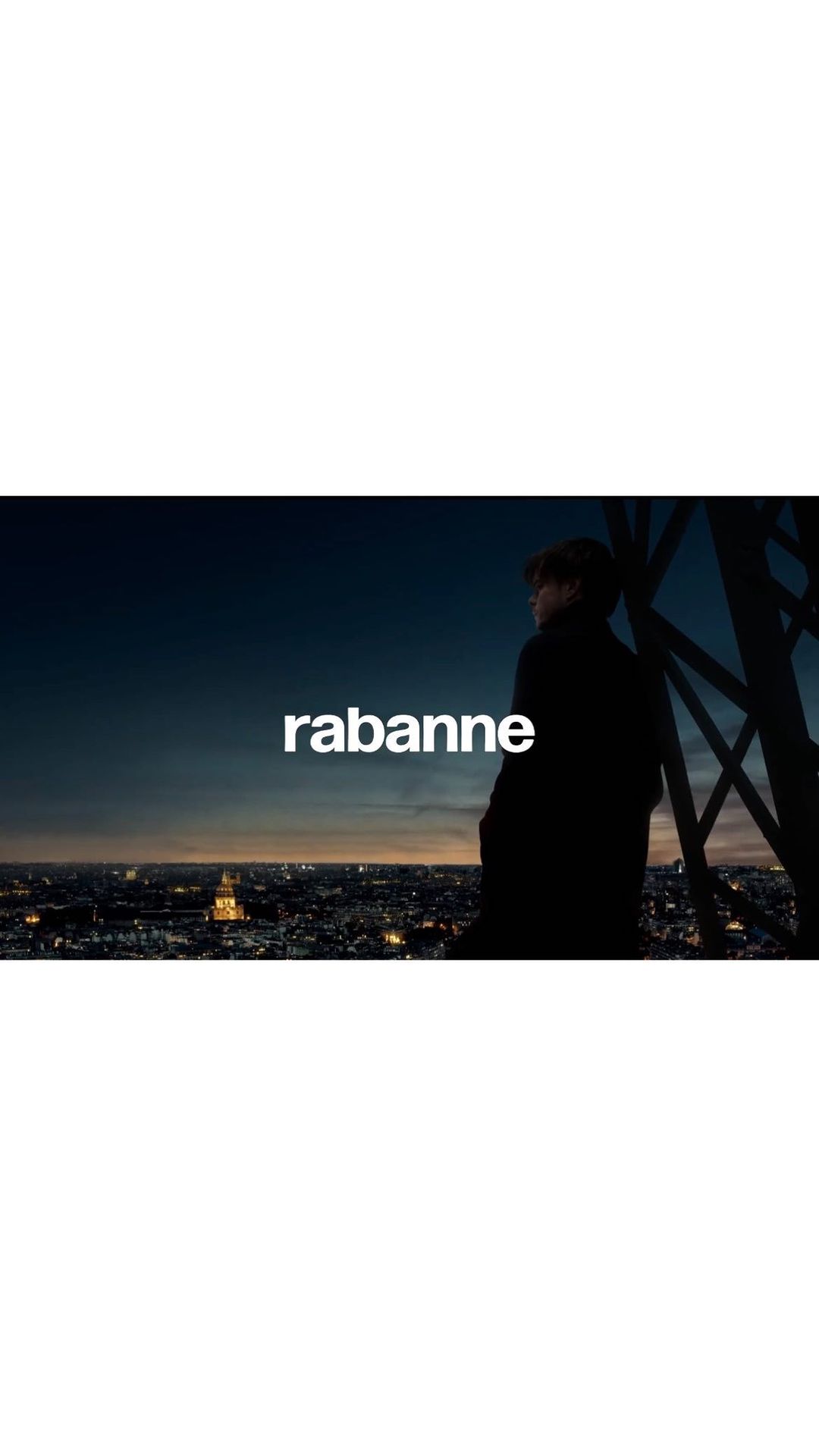 A man in silhouette overlooks a cityscape at night, standing near the Eiffel Tower, with the logo "rabanne" displayed.