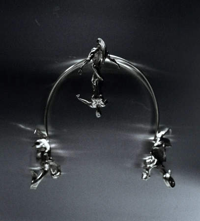 Abstract metallic sculpture featuring stylized human figures connected by an arc, set against a dark gradient background.