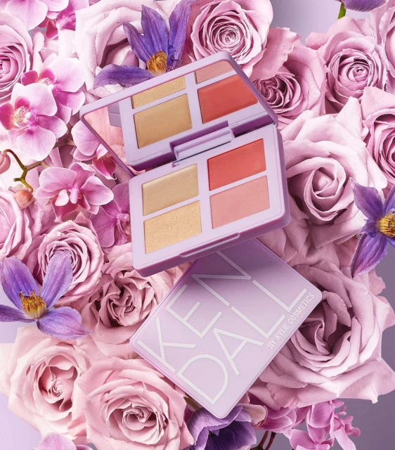 Kylie Cosmetics' Kendall palette atop pink roses, showcasing neutral and coral shades for beauty and fashion visuals.