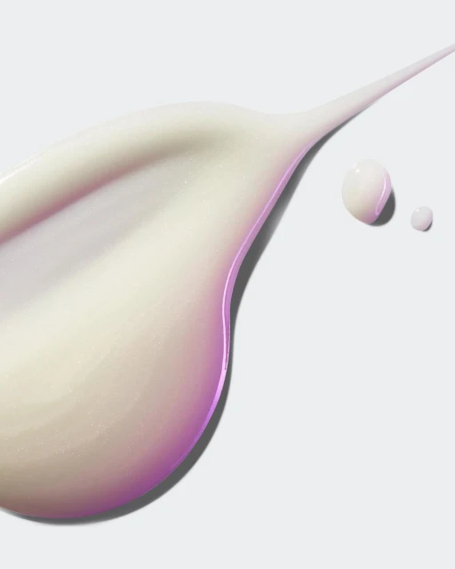 Close-up studio shot of thick cream in a curved swath with droplets, against a solid white backdrop. Minimalist, beauty concept.