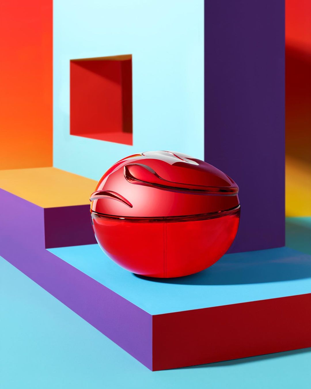 Geometric still life featuring a red orb on a blue platform against a multicolored background with square architectural elements.