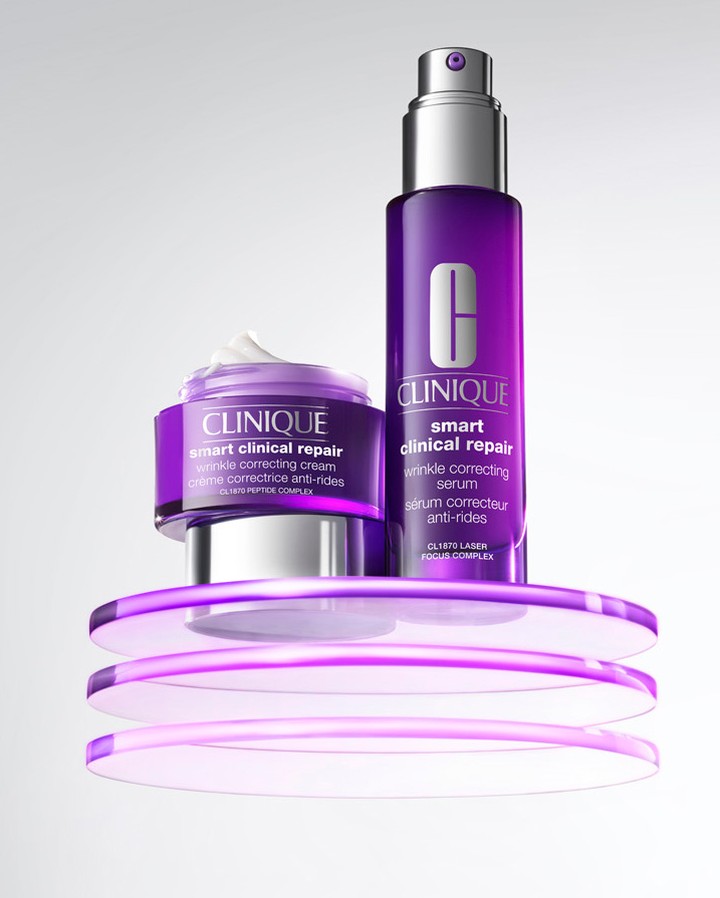 Clinique skincare product set on a translucent purple platform. Includes a jar of wrinkle correcting cream and a bottle of serum.