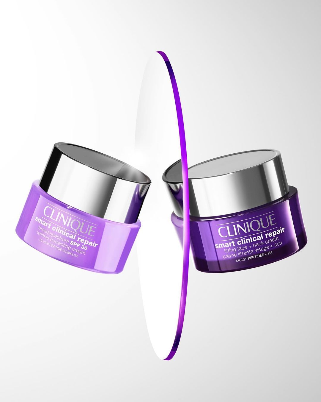 Two purple and silver Clinique Smart Clinical Repair SPF 50 skincare containers floating in a studio setting with a purple line.