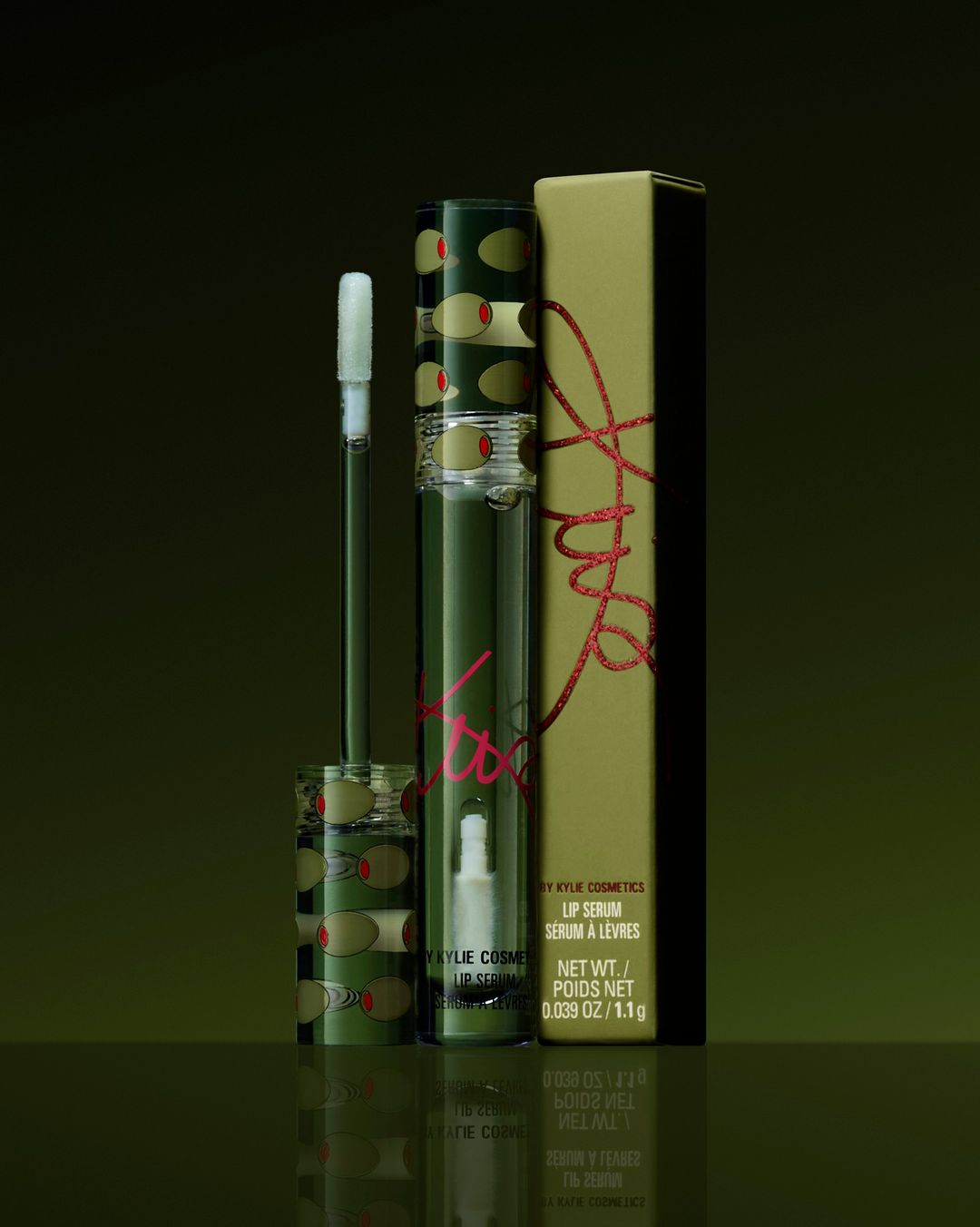 Kylie Cosmetics lip serum product shot. Cosmetic tube and box with olive pattern on a green surface, product photography.