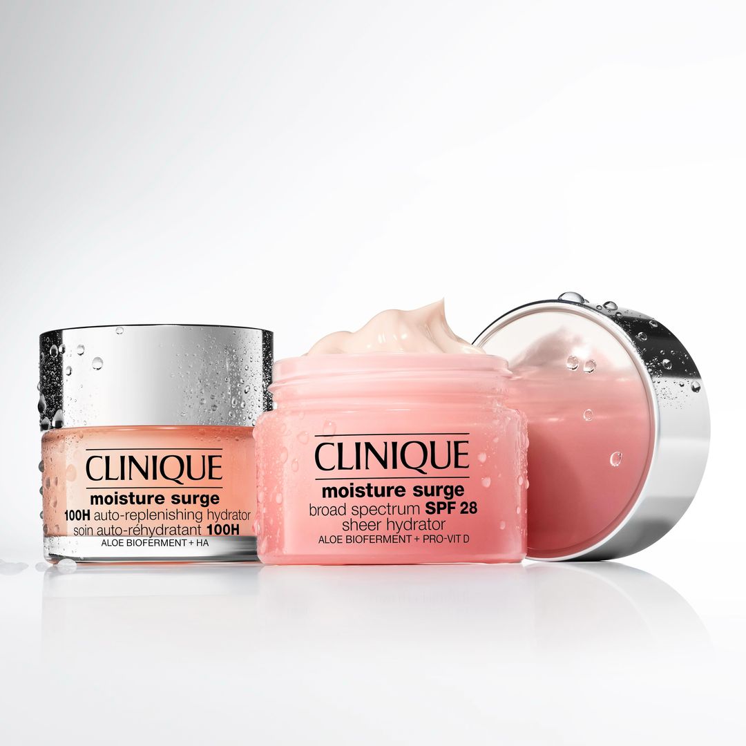 Two jars of Clinique Moisture Surge moisturizer are displayed against a white background, one with a silver lid and one pink.