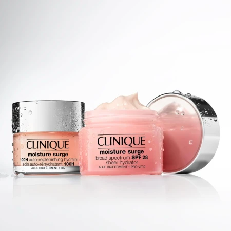 Two jars of Clinique Moisture Surge moisturizer are displayed against a white background, one with a silver lid and one pink.