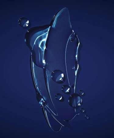 Close-up of translucent blue gel smear with water droplets on a navy blue backdrop, creating a cool, textured, and abstract visual.
