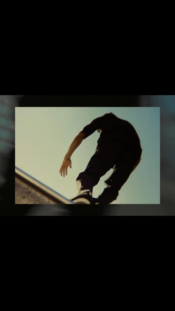 Man skateboarding on a ramp with a blue sky in the background. The skateboarder is silhouetted against the bright sky.