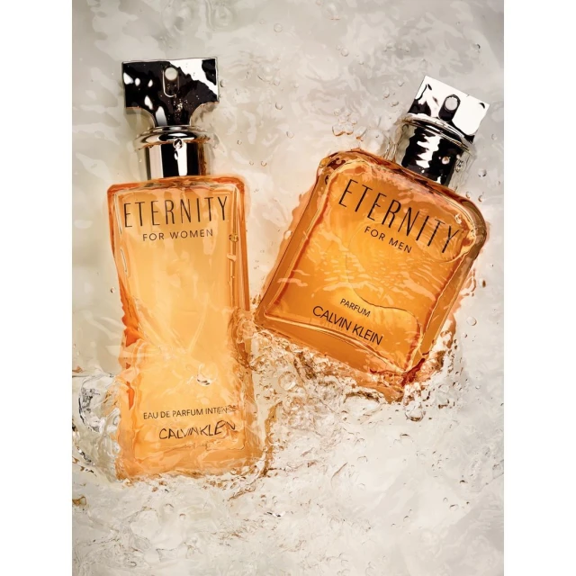 Two bottles of Calvin Klein Eternity perfume, one for men and one for women, are displayed against a white, semi-transparent backdrop.