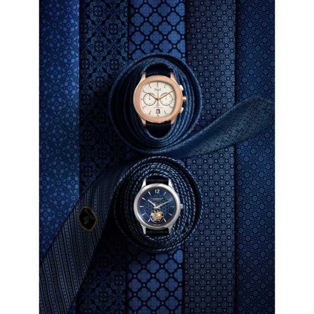 Overhead studio shot of two wristwatches nestled on folded blue patterned ties, luxury accessories, sophisticated timepieces, rich blue hues.