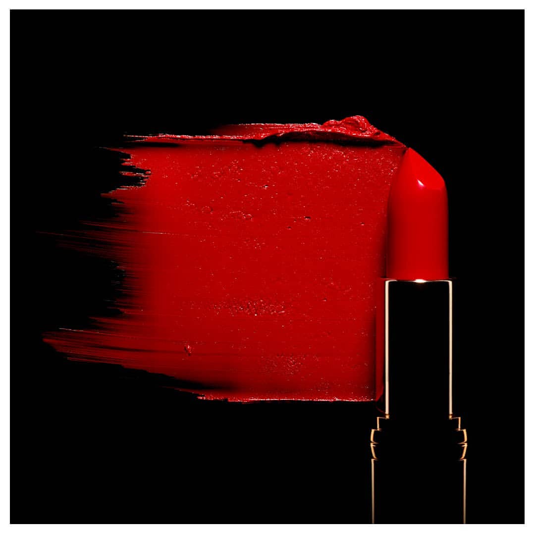 Close-up of red lipstick smear with lipstick tube on a black background, beauty product photography for cosmetics and makeup concepts.