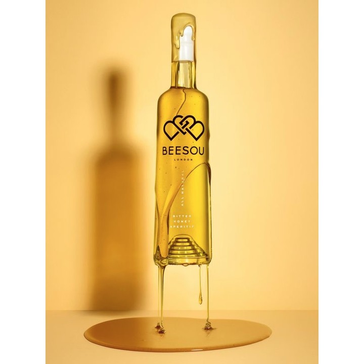 Beesou Bitter Honey Aperitif bottle with honey drippings on gold background, showcasing a unique and flavorful beverage product.