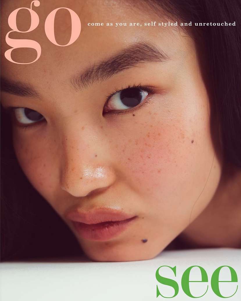 Close-up portrait of an Asian woman with freckles and mole posing for a beauty and fashion editorial magazine cover.