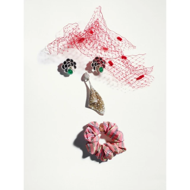Elegant earrings and a scrunchie on a white background, complemented by a delicate red veil, capturing a high-fashion aesthetic.