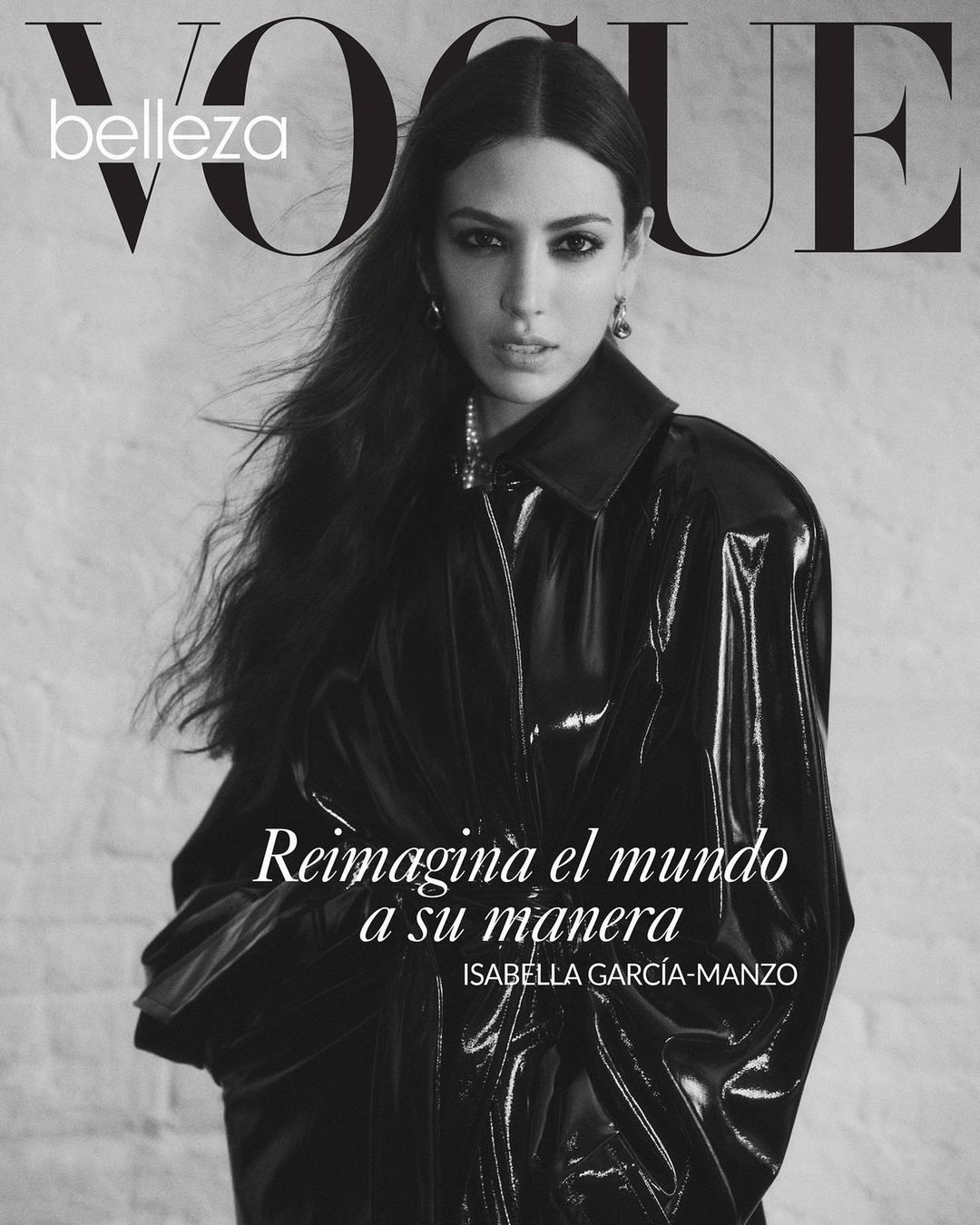 Black-and-white Vogue magazine cover featuring a woman in a shiny black jacket, posing against a textured light-colored background.