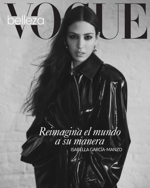 Black-and-white Vogue magazine cover featuring a woman in a shiny black jacket, posing against a textured light-colored background.