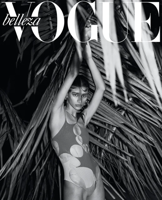 Vogue magazine cover featuring a woman in a printed swimsuit with palm fronds, in a black-and-white fashion photography setting.