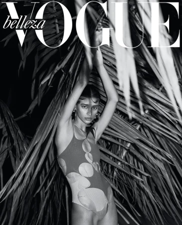 Vogue magazine cover featuring a woman in a printed swimsuit with palm fronds, in a black-and-white fashion photography setting.
