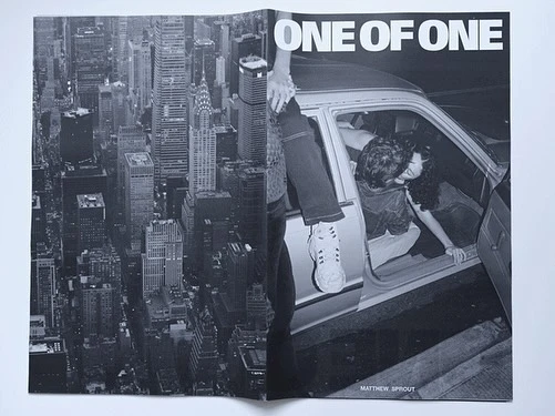 Monochrome image in a magazine spread features a couple inside a car with a cityscape view of New York City in the background.