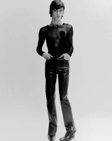 Monochrome portrait of a young male model wearing a sheer black top and leather trousers by Matthieu Delbreuve