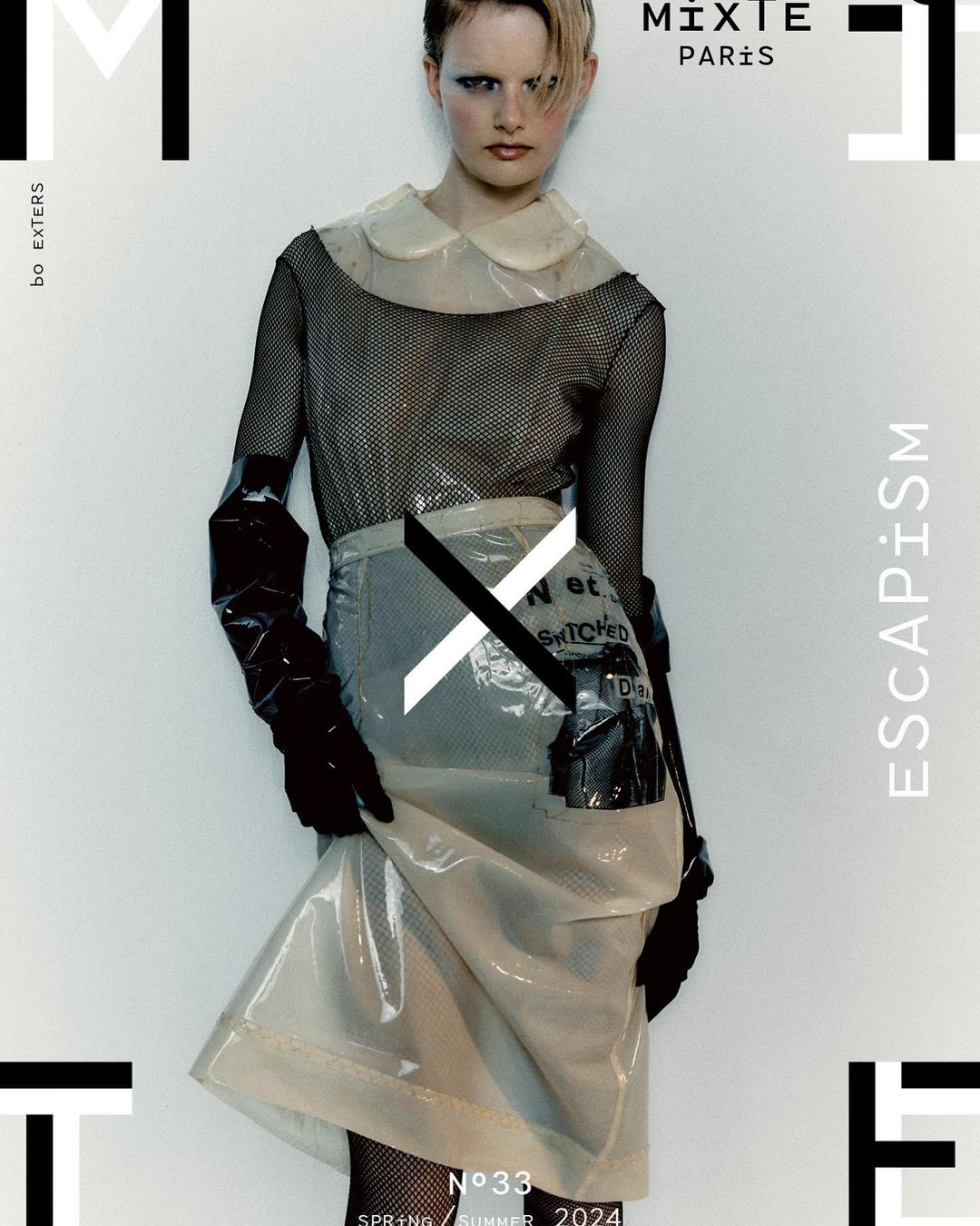 Fashion editorial cover featuring a model wearing a transparent plastic skirt and top with black mesh top, set against a white background.