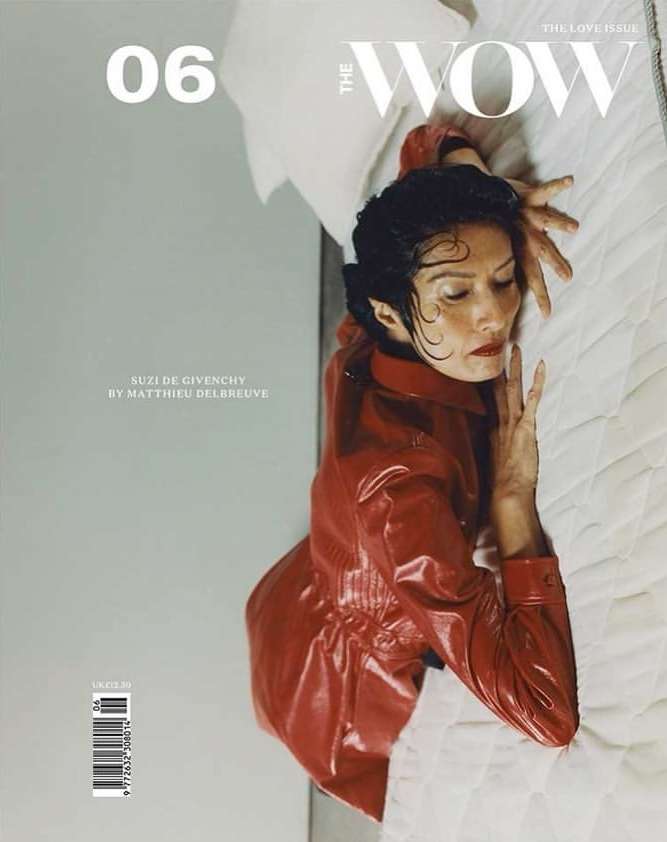 Magazine cover featuring a woman in a red jacket lying on a white quilted surface, with magazine text and branding visible.